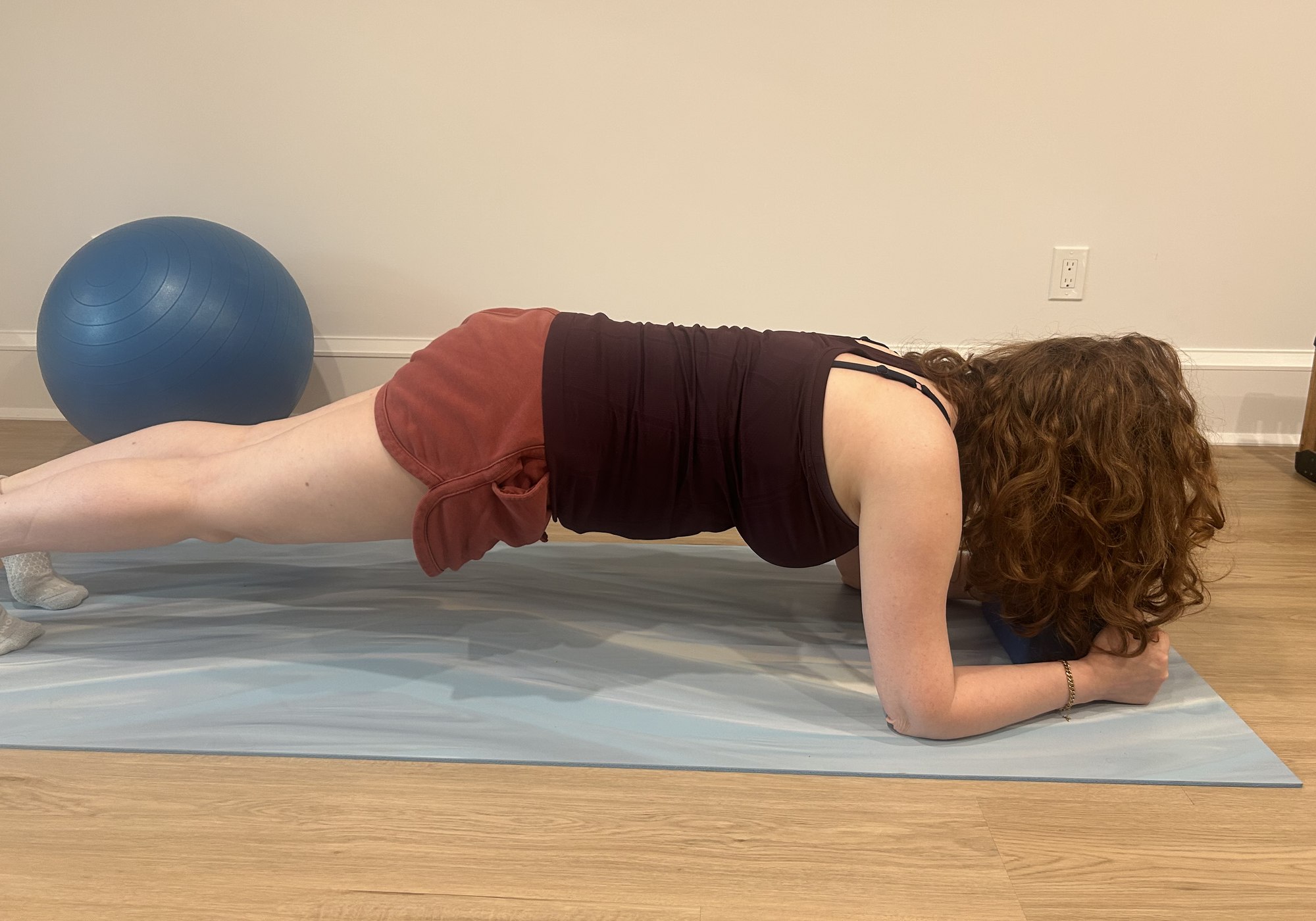 A client holding a forearm plank on a mat during a private training session