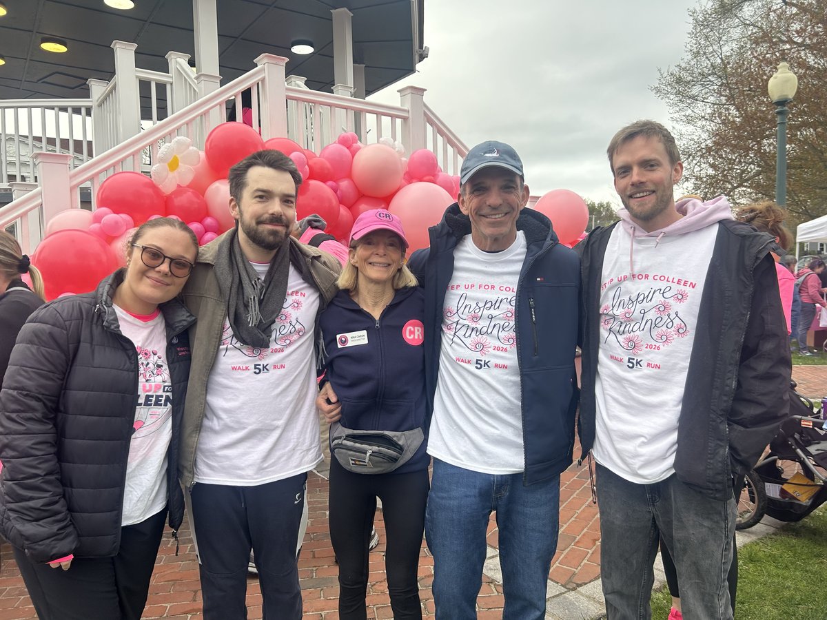 Nina Caron with family and volunteers in Step Up for Colleen shirts by the bandstand and pink balloons