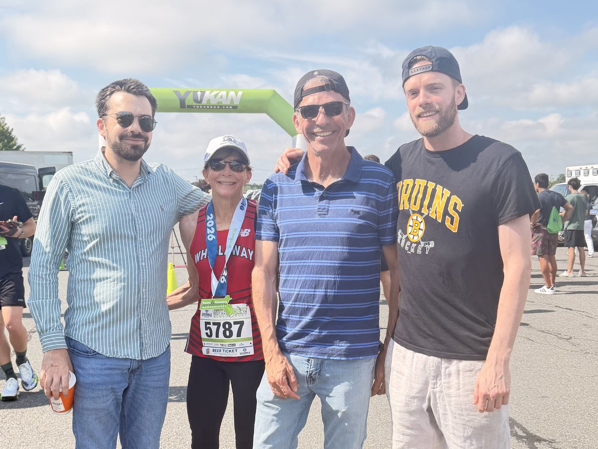 Nina Caron in her racing singlet with her family at a race finish line